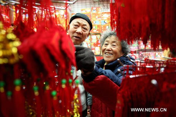 Customers select New Year decorations in a market in Macao, south China, Jan. 11, 2011 for the upcoming Spring Festival of the Year of Rabbit in Chinese Lunar Calendar. [Xinhua]