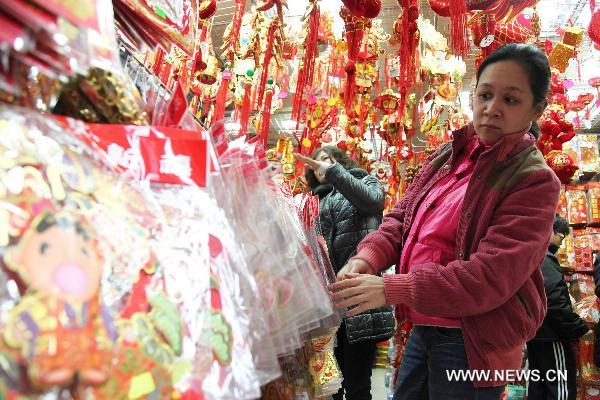 Customers select New Year decorations in a market in Macao, south China, Jan. 11, 2011 for the upcoming Spring Festival of the Year of Rabbit in Chinese Lunar Calendar. [Xinhua]