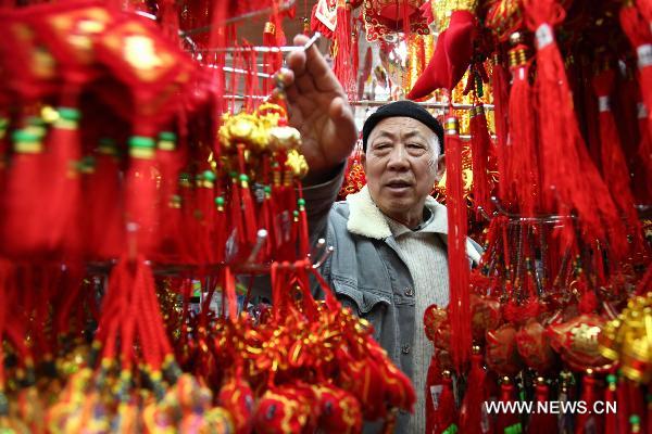 A customer selects New Year decorations in a market in Macao, south China, Jan. 11, 2011 for the upcoming Spring Festival of the Year of Rabbit in Chinese Lunar Calendar. [Xinhua]