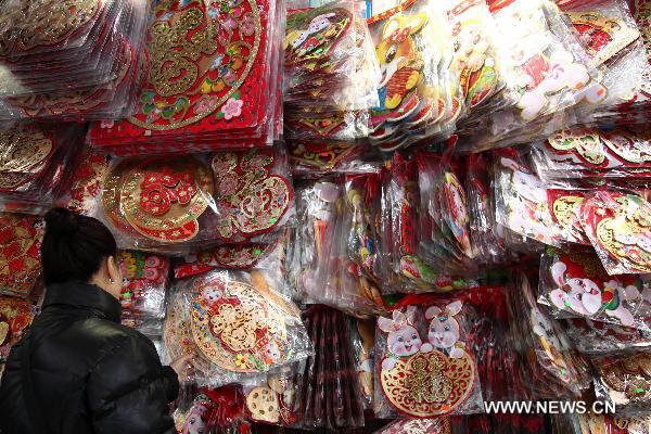  A customer selects New Year decorations in a market in Macao, south China, Jan. 11, 2011 for the upcoming Spring Festival of the Year of Rabbit in Chinese Lunar Calendar. [Xinhua]