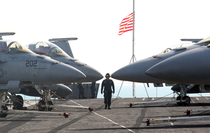 A soldier walks past the fighter jets on the deck of the U.S. aircraft carrier USS Carl Vinson which is anchored at a South Korean navy port in Busan, South Korea on Jan. 11, 2011. [Xinhua]