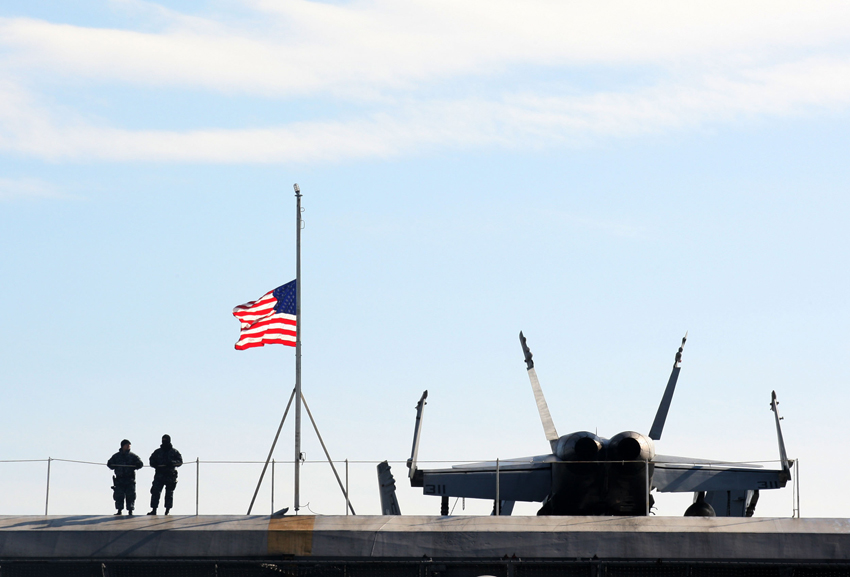 A U.S. national flag flies on the deck of the U.S. aircraft carrier USS Carl Vinson which is anchored at a South Korean navy port in Busan, South Korea, on Jan. 11, 2011. [Xinhua]