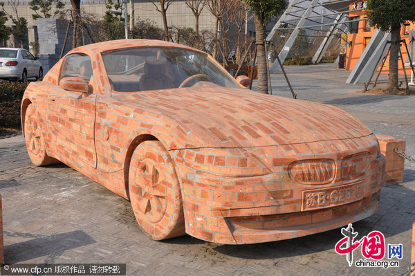 A BMW made of bricks rests by the road in Wuxi, East China&apos;s Jiangsu province, Jan 11, 2010. The car, the same shape and size of a real BMW, is an artwork by Dai Yun, a sculptor in Shenzhen, Guangdong province. The cost of the car is 600,000 yuan ($90,641). [CFP]