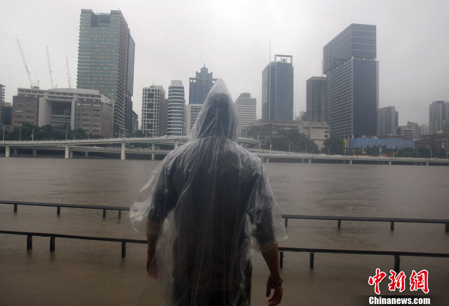 A man looks at the rising Brisbane River in central Brisbane Jan 11, 2011. Thousands of people were urged to leave the outskirts of Australia&apos;s third-largest city, Brisbane, on Tuesday as flood waters raced eastwards after a surging two-metre wall of water killed eight people overnight. [Chinanews.com]