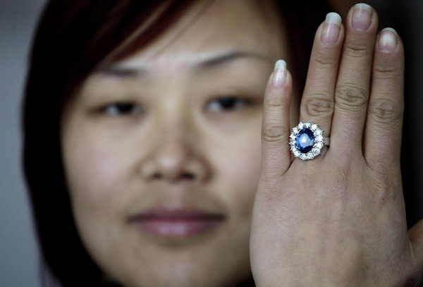 A woman shows a replica of the British royal engagement ring at a jewellery factory in Yiwu, Zhejiang province January 12, 2011. Chinese manufacturers are cashing in on the British royal wedding craze as they churn out tens of thousands of replica royal engagement rings for the world. [China Daily/Agencies]