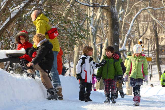 Children walk in Central Park after an overnight snowfall in New York, the United States, Jan. 12, 2011. [Xinhua]