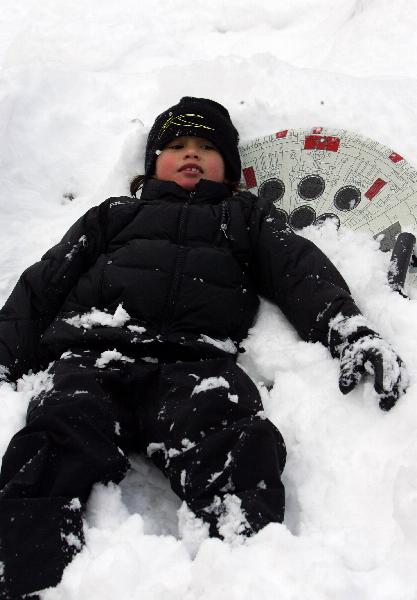 A child plays in Central Park after an overnight snowfall in New York, the United States, Jan. 12, 2011. [Xinhua] 