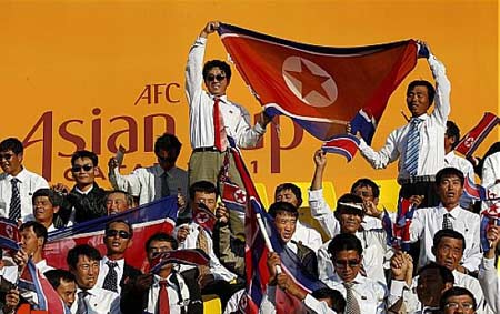 DPRK&apos;s cheering squad wave national flags during their 2011 Asian Cup Group D soccer match against United Arab Emirates at Qatar Sports Club stadium in Doha, Jan 11, 2011. [msn.com.cn] 