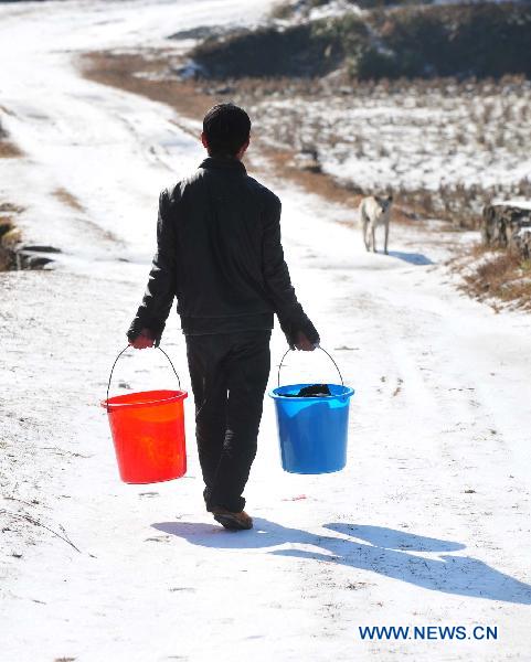 A villager goes outdoors to wash clothes in Ziyuan County, south China&apos;s Guangxi Province, Jan. 12, 2011. After a ten-day icy-rain disaster, the weather improved a lot in Ziyuan County on Wednesday. The sun came out, leading to a temperature rise and the melting of ice and snow. [Xinhua]