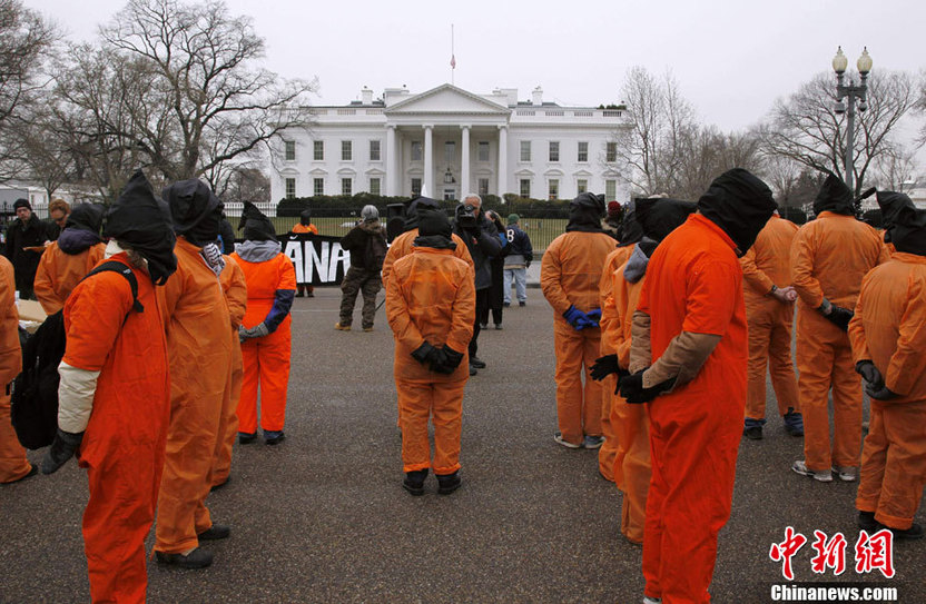 Demonstrators in orange jumpsuits and hoods file in for a rally to &apos;urge President Obama to close the U.S.-controlled detention center in Guantanamo Bay, Cuba on its 9th anniversary&apos; in Washington on January 11, 2011. [CFP]