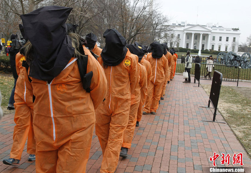 Demonstrators in orange jumpsuits and hoods file in for a rally to &apos;urge President Obama to close the U.S.-controlled detention center in Guantanamo Bay, Cuba on its 9th anniversary&apos; in Washington on January 11, 2011. [CFP]