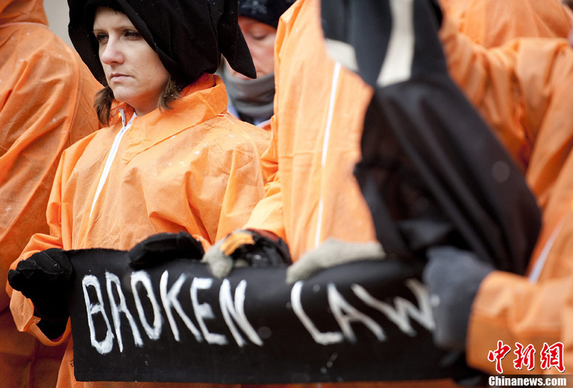 Demonstrators in orange jumpsuits and hoods file in for a rally to &apos;urge President Obama to close the U.S.-controlled detention center in Guantanamo Bay, Cuba on its 9th anniversary&apos; in Washington on January 11, 2011. [CFP]