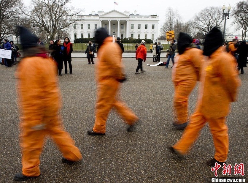 Demonstrators in orange jumpsuits and hoods file in for a rally to &apos;urge President Obama to close the U.S.-controlled detention center in Guantanamo Bay, Cuba on its 9th anniversary&apos; in Washington on January 11, 2011. [CFP]