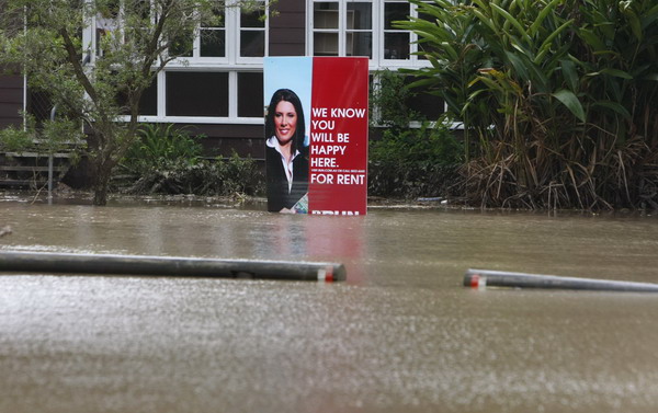 A rental sign for a house is seen on a flooded street in the Brisbane suburb of Toowong January 13, 2011. Flood water in Australia&apos;s third-biggest city peaked below feared catastrophic levels on Thursday but Brisbane and other devastated regions faced years of rebuilding and even the threat of fresh floods in the weeks ahead.[China Daily/Agencies]