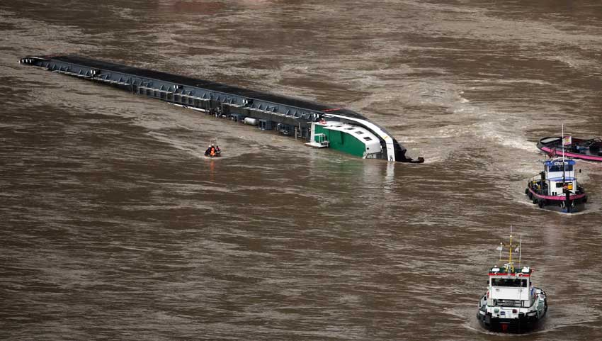 A capsized tanker ship carrying 2,400 tons of sulphuric acid is surrounded by tug boats in the middle of the Rhine (Rhein) river, Europe&apos;s most important shipping way near Sankt Goarshausen January 13, 2011. Two of four crew members were rescued while two others are still being searched for, police said. [Xinhua]