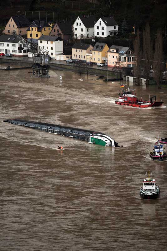 A capsized tanker ship carrying 2,400 tons of sulphuric acid is surrounded by tug boats in the middle of the Rhine (Rhein) river, Europe&apos;s most important shipping way near Sankt Goarshausen January 13, 2011. Two of four crew members were rescued while two others are still being searched for, police said. [Xinhua]