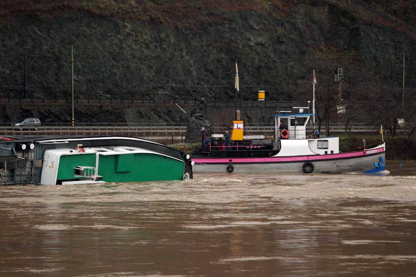 A capsized tanker ship carrying 2,400 tons of sulphuric acid is surrounded by tug boats in the middle of the Rhine (Rhein) river, Europe&apos;s most important shipping way near Sankt Goarshausen January 13, 2011. Two of four crew members were rescued while two others are still being searched for, police said. [Xinhua]