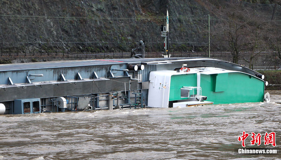 A capsized tanker ship carrying 2,400 tons of sulphuric acid is surrounded by tug boats in the middle of the Rhine (Rhein) river, Europe&apos;s most important shipping way near Sankt Goarshausen January 13, 2011. Two of four crew members were rescued while two others are still being searched for, police said. [photo/Chinanews.com]