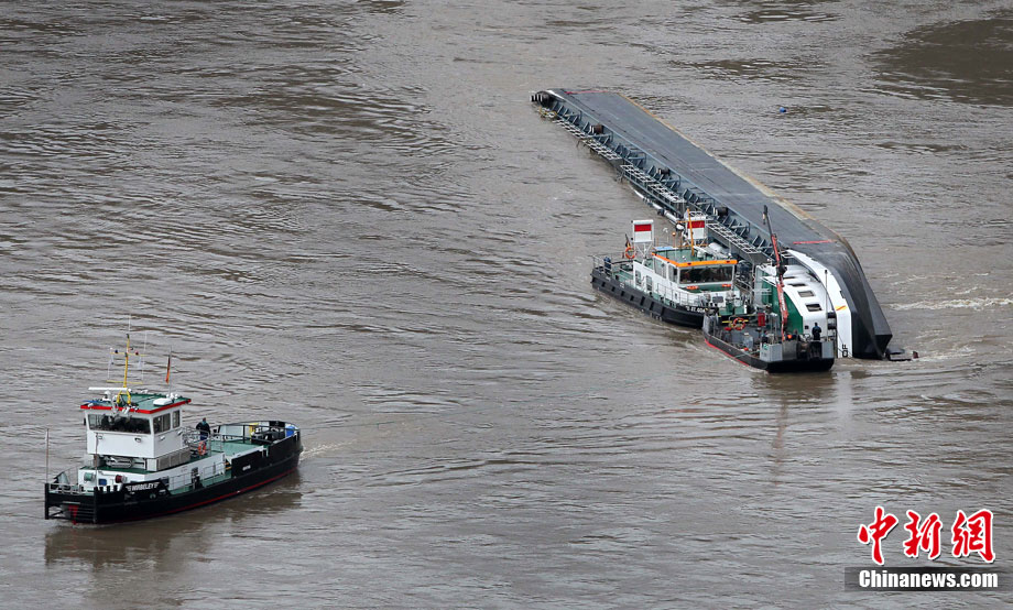 A capsized tanker ship carrying 2,400 tons of sulphuric acid is surrounded by tug boats in the middle of the Rhine (Rhein) river, Europe&apos;s most important shipping way near Sankt Goarshausen January 13, 2011. Two of four crew members were rescued while two others are still being searched for, police said. [photo/Chinanews.com]