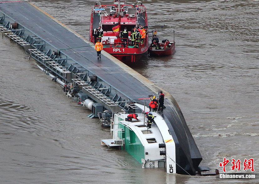 A capsized tanker ship carrying 2,400 tons of sulphuric acid is surrounded by tug boats in the middle of the Rhine (Rhein) river, Europe&apos;s most important shipping way near Sankt Goarshausen January 13, 2011. Two of four crew members were rescued while two others are still being searched for, police said. [photo/Chinanews.com]