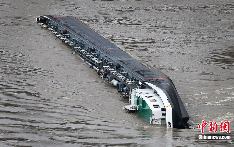 A capsized tanker ship carrying 2,400 tons of sulphuric acid is surrounded by tug boats in the middle of the Rhine (Rhein) river, Europe&apos;s most important shipping way near Sankt Goarshausen January 13, 2011. Two of four crew members were rescued while two others are still being searched for, police said. [photo/Chinanews.com]