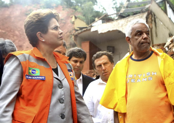 Brazil&apos;s President Dilma Rousseff (L) stands with residents whose homes were damaged or destroyed by flooding and landslides in Nova Friburgo, Jan 13, 2011. [China Daily/Agencies]