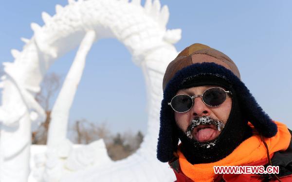 Photo taken on Jan. 6, 2011 shows a man making faces with his work at the 16th Snow Sculpture Contest held in Harbin, capital of northeast China&apos;s Heilongjiang Province. The 16th Snow Sculpture Contest wrapped up in Harbin on Thursday, with a Russian team, a Thai team and a Chinese team winning the champion and runner-ups respectively. [Xinhua]