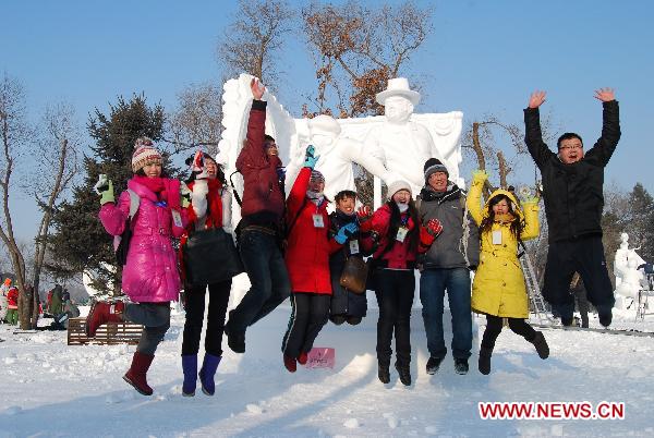 Photo taken on Jan. 6, 2011 shows volunteers cheering in front of the championship work at the 16th Snow Sculpture Contest held in Harbin, capital of northeast China&apos;s Heilongjiang Province. The 16th Snow Sculpture Contest wrapped up in Harbin on Thursday, with a Russian team, a Thai team and a Chinese team winning the champion and runner-ups respectively.[Xinhua]