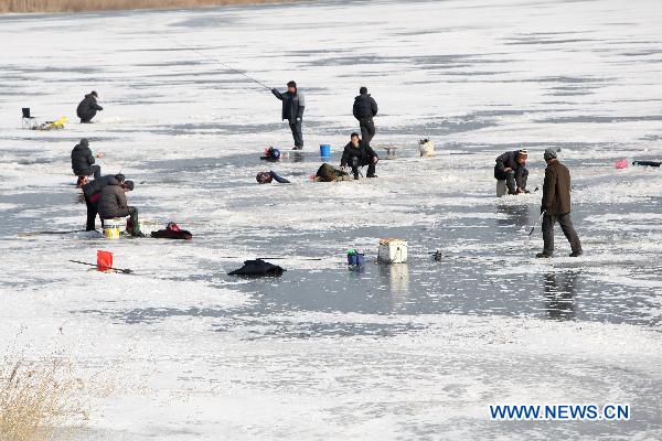 Contestants fish on the iced Waijia River during a fishing contest in Yantai, east China&apos;s Shandong Province, Jan. 12, 2011. More than 50 fishing fans attended the contest on Wednesday. [Xinhua] 