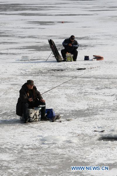 Contestants fish on the iced Waijia River during a fishing contest in Yantai, east China&apos;s Shandong Province, Jan. 12, 2011. More than 50 fishing fans attended the contest on Wednesday. [Xinhua]