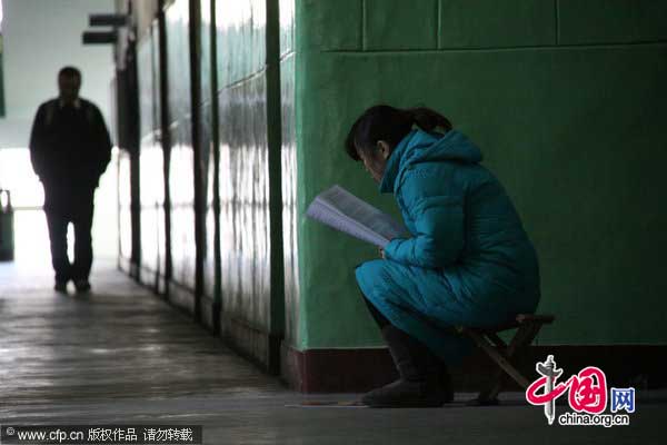 A student studies in a corridor of Shandong Normal University in Jinan, East China&apos;s Shandong province, Jan 13, 2011. Classrooms have been fully packed with the advent of the annual exam for postgraduate schools, driving some students to sit outside classrooms. The exam takes place on Jan 15 and Jan 16 this year. As many as 1.5 million people will take the exam, 100,000 more than in 2010. [Photo/CFP]