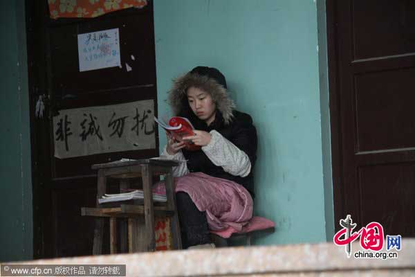 A student studies outside a classroom in Shandong Normal University in Jinan, Shandong province, Jan 13, 2011. [Photo/CFP] 