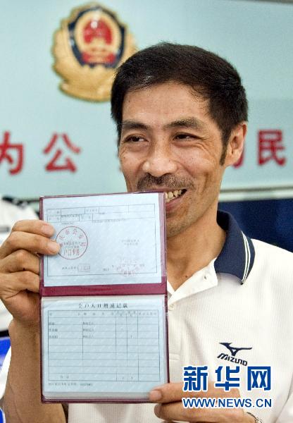 Chen Gang, the first farmer to apply for an urban hukou when Chongqing began its household registration reform, presents his residence book outside a police station in Chongqing on Aug. 1, 2010.