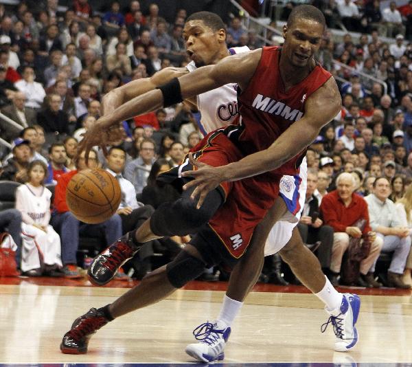 Miami Heat's Chris Bosh (R) loses control of the ball in front of Los Angeles Clippers Ryan Gomes during their NBA basketball game in Los Angeles, California, January 12, 2011. (Xinhua/Reuters Photo)