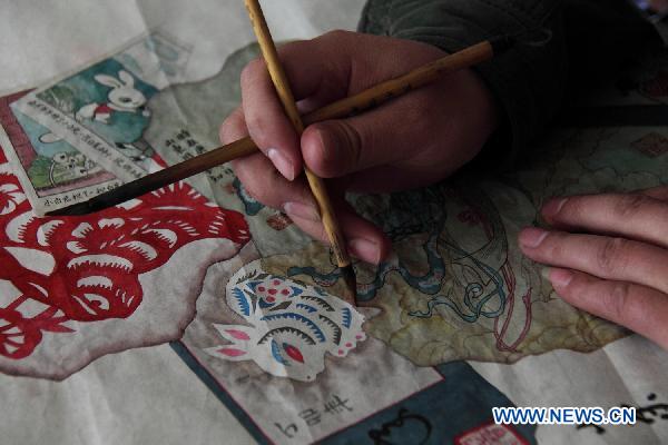 Folk artist Geng Xuezhi is in the process of creating a 'Jinhuidui' work in Zibo, east China's Shandong Province, Jan. 12, 2011. 'Jinhuidui', literally meaning a pile of old things from ash, is a branch of traditional Chinese painting, originating from Yuan Dynasty. A frame is set before-hand in creating a 'Jinhuidui' painting. Then different old things, such as a piece of worn-out paper, a wrinkled picture, or a yellow newspaper, are painted in the frame. As the creation of 'Jinhuidui' works requires great skills and a long time, this art is in the danger of being lost. 