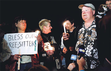 Protester Camron Stone speaks during a candlelight vigil in support of tree sitters who are attempting to keep oak trees from being felled in Arcadia, California. [AP]