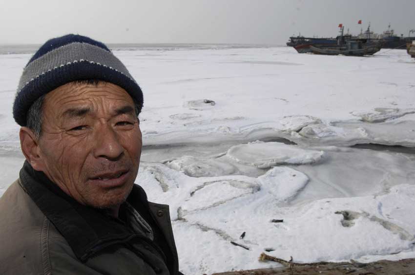 Local fisherman Li Mingqing stands by the iced sea at Laizhou Bay in Laizhou, eastern China&apos;s Shandong Province. The area of iced sea has amounted to 3,000 square kilometers due to continuous cold waves while most offshore activities were forced to be halted. [Xinhua]