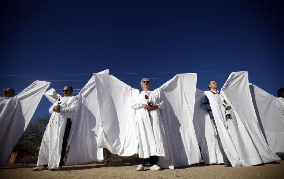 Supporters of federal judge John Roll, and dressed as angels, stand outside his funeral mass in Tucson, Arizona January 14, 2011. A devout Catholic, Roll was also a close friend to Congresswoman Gabrielle Giffords who was also shot on January 8, 2011. Roll was shot to death as he dropped by to see her at a constituents meeting outside a north Tucson grocery store last Saturday, on his way home from mass. [[China Daily/Agemcies]