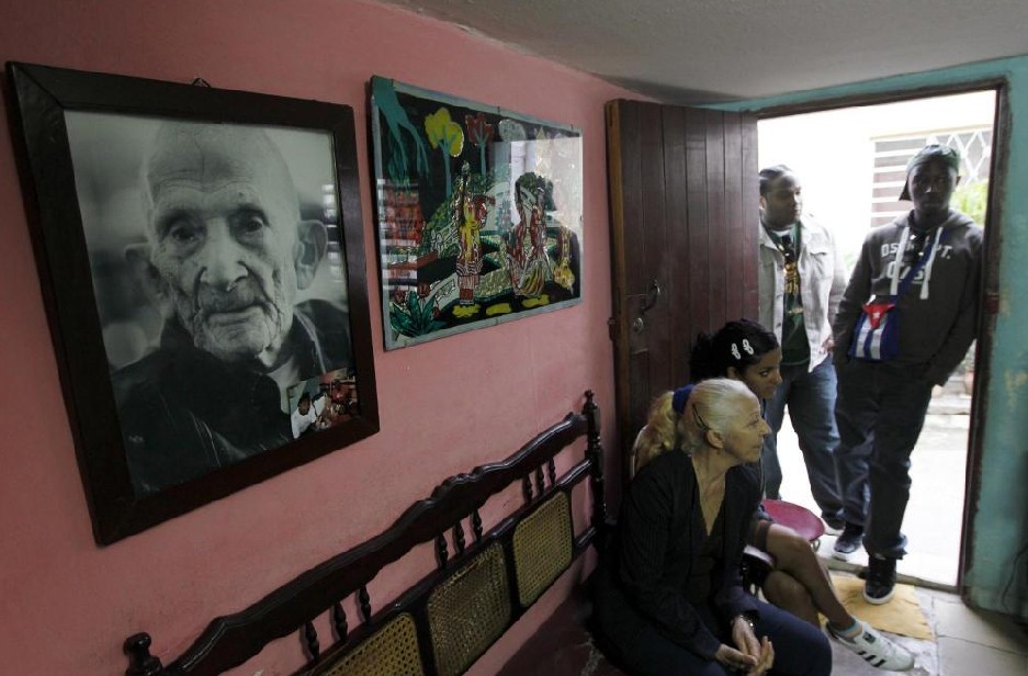 Relatives of Ignacio Cubilla Banos stand near a picture of him during his 111th birthday celebration in Havana January 13, 2011. Banos, a former sugar factory worker who has 11 children, 40 grandchildren and 15 great-grandchildren, celebrated his 111th birthday on Thursday.[[China Daily/Agemcies]