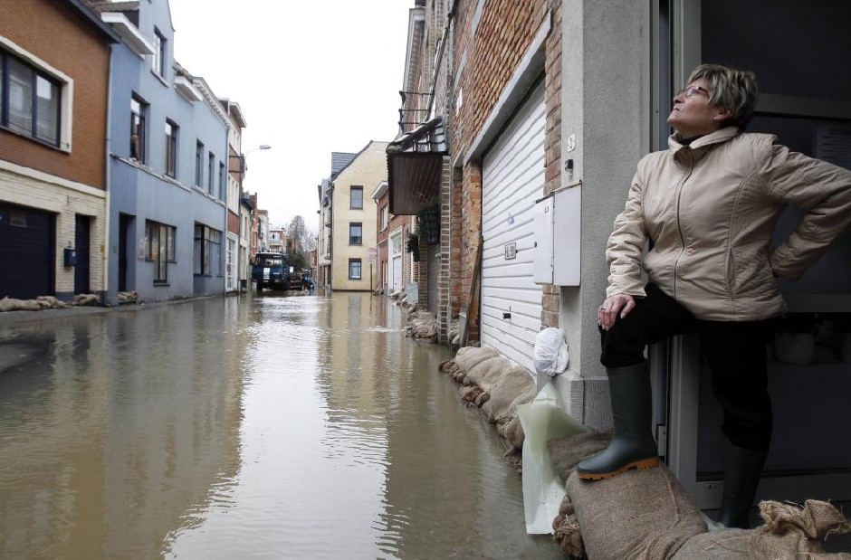 A woman looks at a flooded street in Geraardbergen January 14, 2011, where the Dender River burst its banks. Several rivers burst their banks due to heavy rain flooding several towns and villages in Belgium, local media said.[[China Daily/Agemcies]