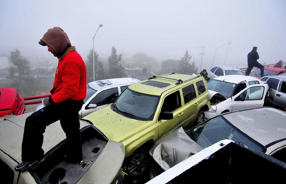 Drivers stand over vehicles following a large car accident on a highway on the outskirts of Saltillo, in the Mexican state of Coahuila January 13, 2011. Icy roads were blamed for a 30 car pile-up on a motorway near Saltillo on Thursday in which ten people were injured, according to local media. [[China Daily/Agemcies]