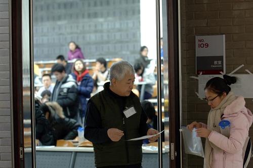 A teacher checking student identifications outside the examination hall at Peking University on Saturday, January 15, 2011.[Photo: gov.cn] 