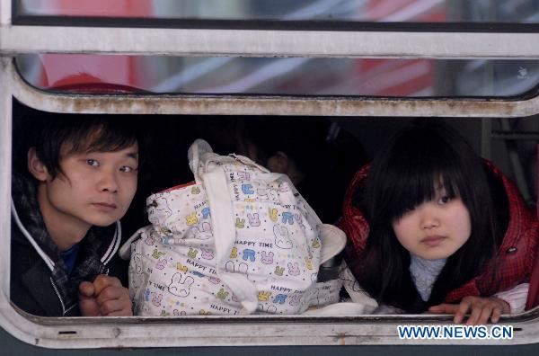 Photo taken on Jan. 15, 2011 shows two passengers on the train in Nanjing, capital of east China's Jiangsu Province. China's annual Spring Festival travel period would last from Jan. 19 to Feb. 27 this year with an estimated passenger flow of 230 million posting an increase of 12.5% year on year according to the Ministry of Railways. (Xinhua) 