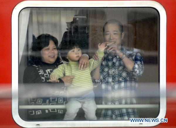 Photo taken on Jan. 15, 2011 shows a couple with their child on the train in Nanjing, capital of east China's Jiangsu Province. China's annual Spring Festival travel period would last from Jan. 19 to Feb. 27 this year with an estimated passenger flow of 230 million posting an increase of 12.5% year on year according to the Ministry of Railways. (Xinhua) 