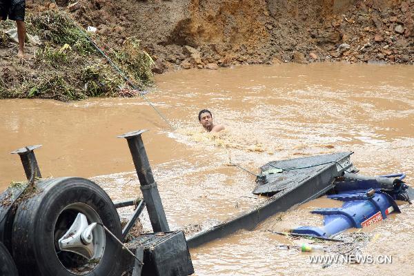 A man tries to reach a truck in the flood in Nova Friburgo, Brazil, Jan. 15, 2011. According to the local government, the death toll caused by this week's heavy rains and mudslide that hit Brazil's Rio de Janeiro state has reached at least 550. (Xinhua/Agencia Estado)