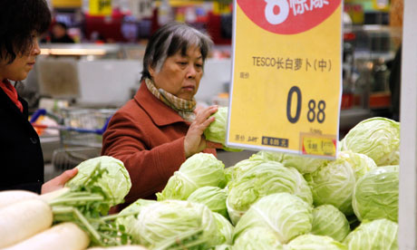 Customers buy cabbages at a supermarket.