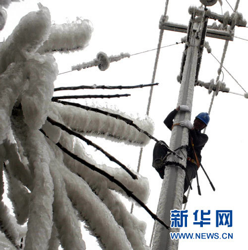 An electrician repairs power lines on a pole in Quanzhou Country, Guangxi Zhuang Autonomous Region on January 7, 2011. Icy weather will return to southern China this week with lower temperatures and heavy freezing rains, the National Meteorological Center forecast over the weekend.  