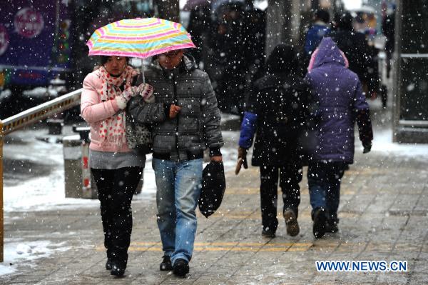 A couple walk on a street in Guiyang, capital of southwest China's Guizhou Province, Jan. 17, 2011. Rain, snow and ice hit the province again from Jan. 16. The lowest temperature of the province dropped to minus 6.1 degrees Celsius at Weining County, which is located in the Wumeng mountain areas. 