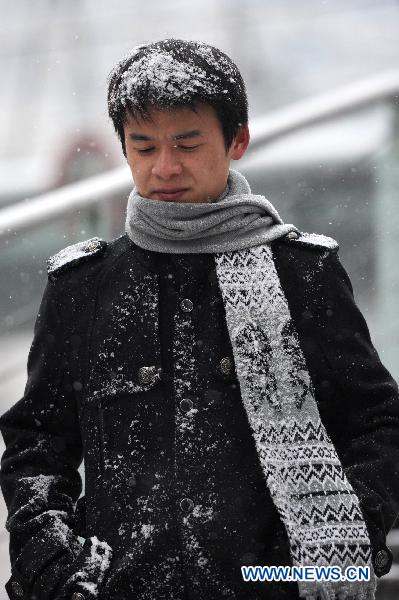 A pedestrian is seen in Guiyang, capital of southwest China's Guizhou Province, Jan. 17, 2011. Rain, snow and ice hit the province again from Jan. 16. The lowest temperature of the province dropped to minus 6.1 degrees Celsius at Weining County, which is located in the Wumeng mountain areas.