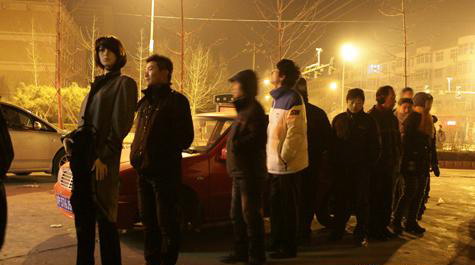 Pictures of a mannequin standing in a line of people waiting to buy tickets home for the Spring Festival have attracted attention on the Internet since Jan 13. The pictures show a man installing a mannequin in the line, so that it could take his place as he had a rest in his car. [Photo/tt.mop.com] 